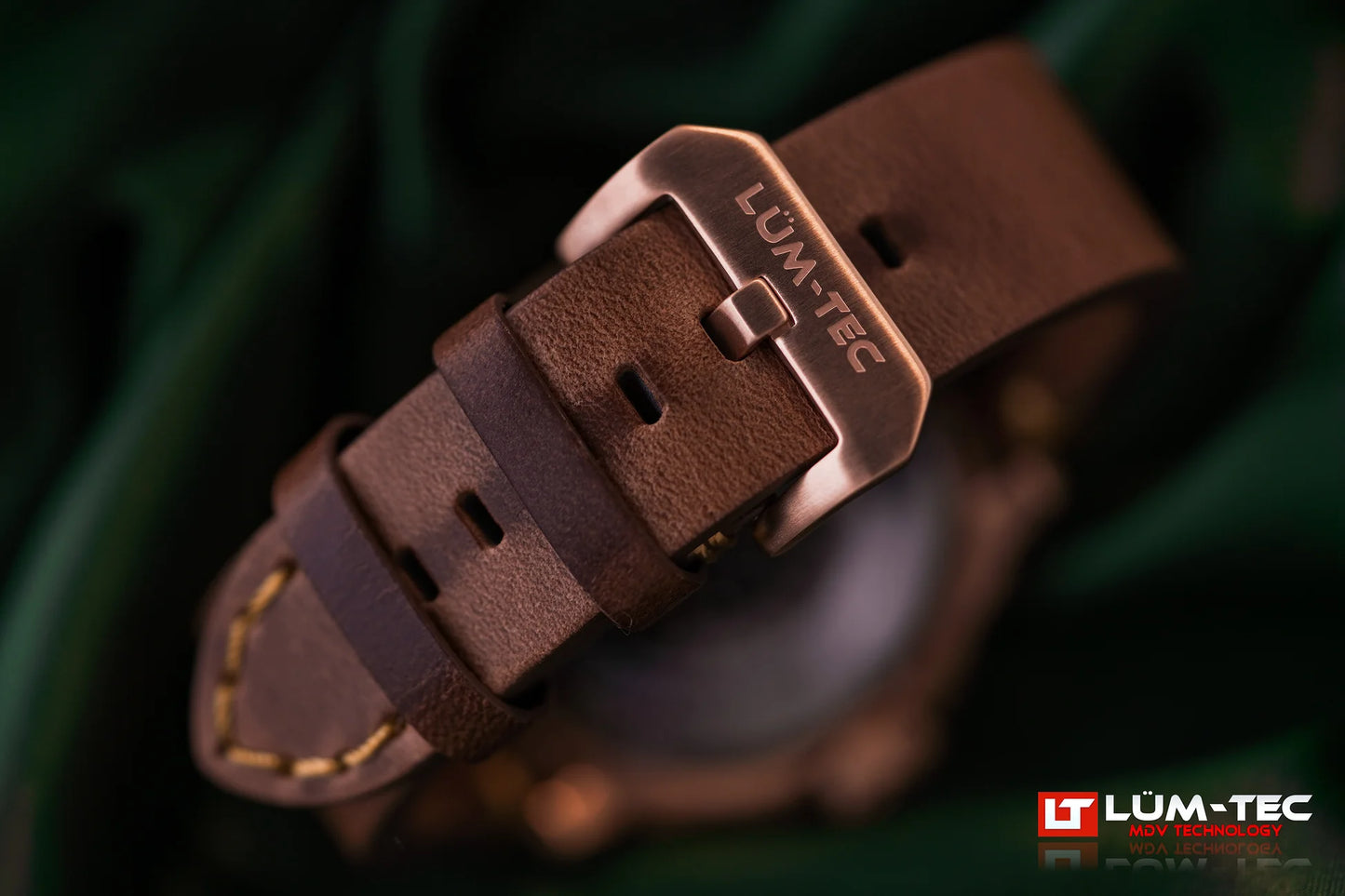 Macro shot of Lum-Tec M94D Bronze showing engraved bronze buckle and Horween leather strap with yellow stitching