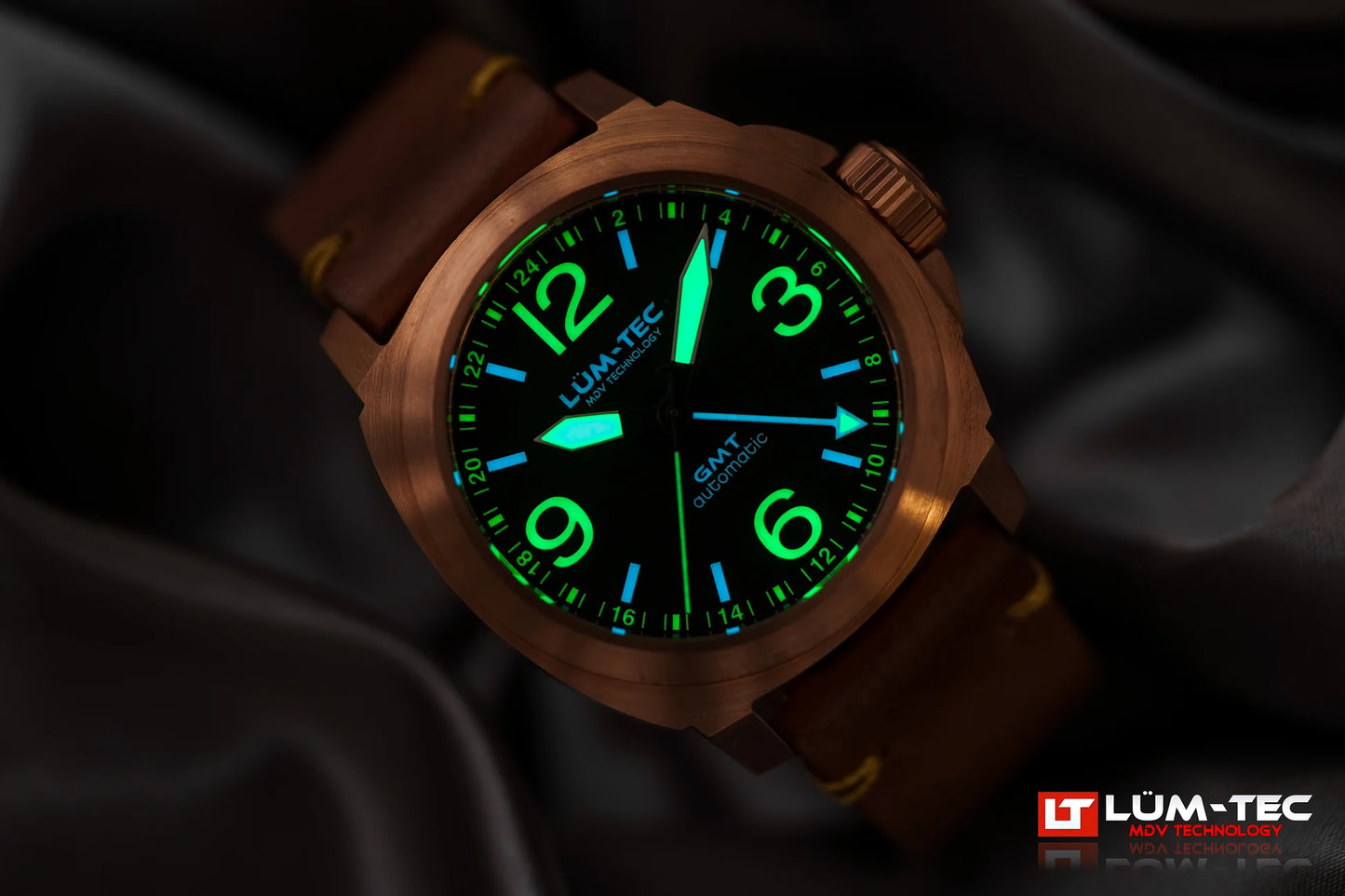 Lum-Tec M94 Bronze GMT lume shot showing bright glow on hands and markers in low light