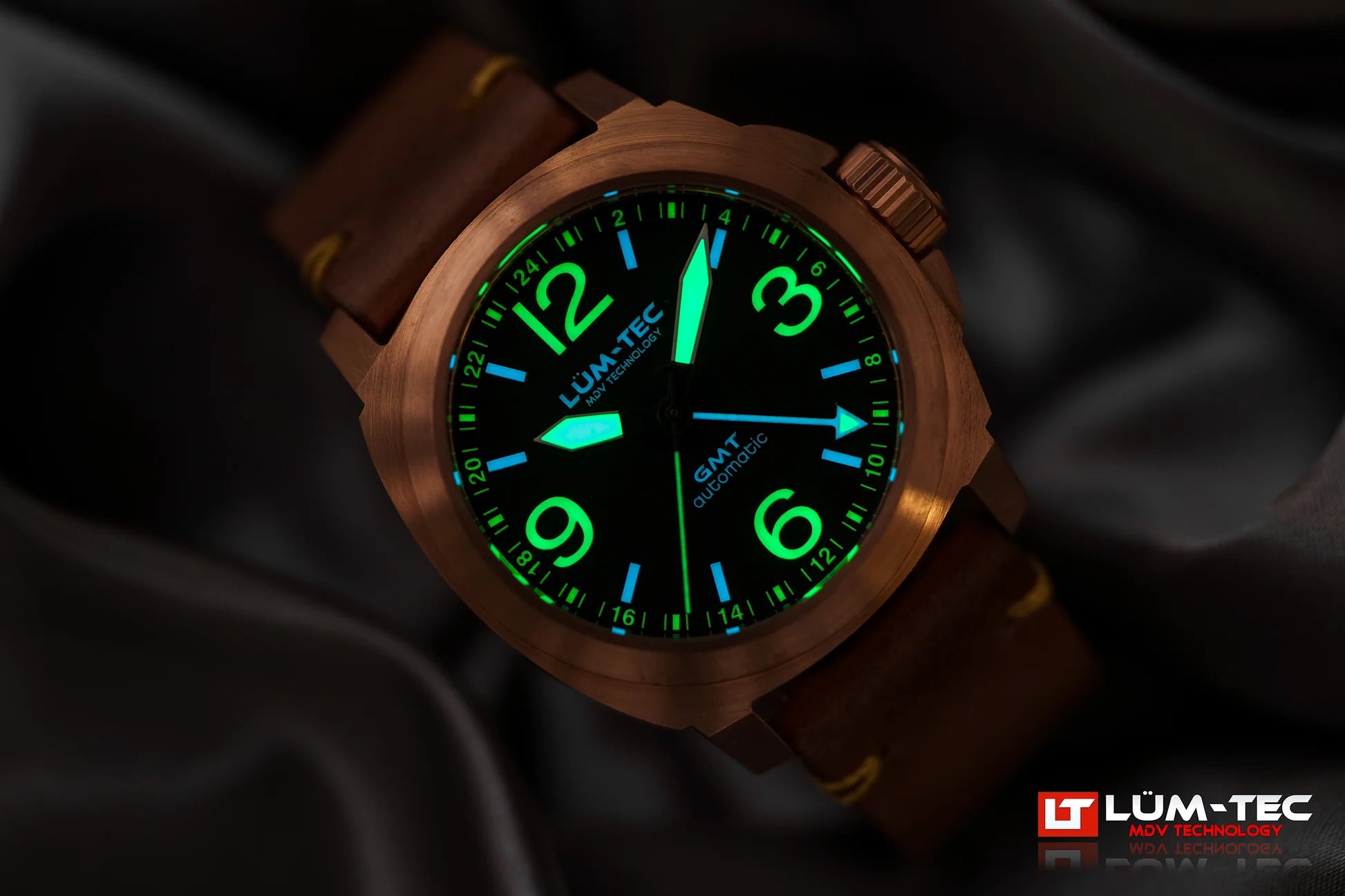 Lum-Tec M94 Bronze GMT lume shot showing bright glow on hands and markers in low light