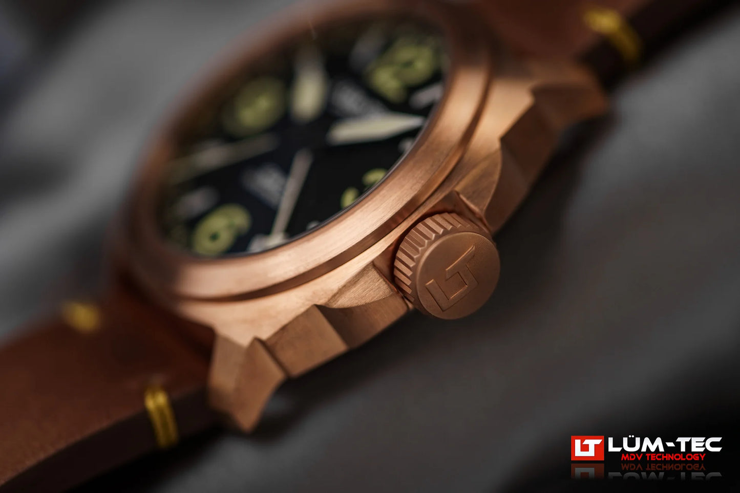 Lum-Tec M94 Bronze GMT side close-up showing brushed bronze case and signed screw-down crown