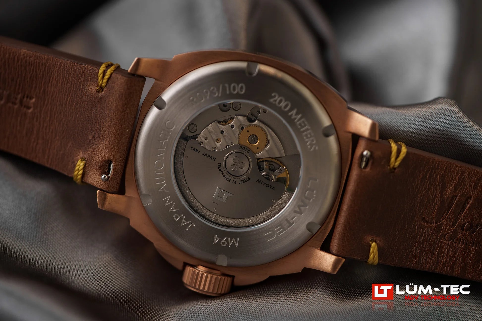 Close-up of Lum-Tec M94 Bronze GMT caseback with visible automatic movement and limited edition marking