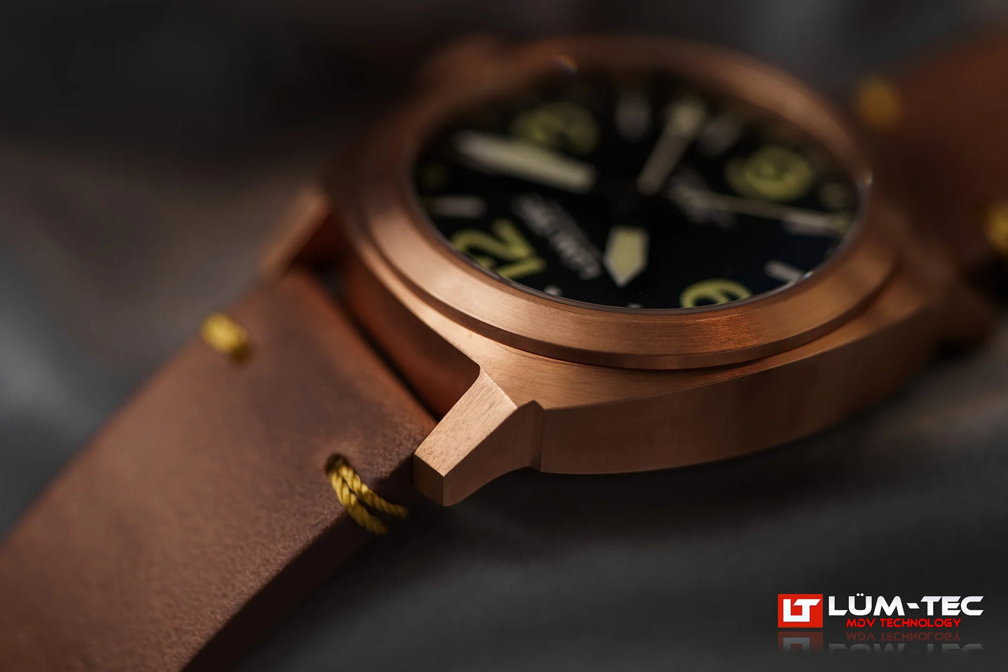 Lum-Tec M94 Bronze GMT side close-up showing brushed bronze case and signed screw-down crown